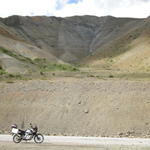 Пейзаж с мотоциклет, жици и планини. 