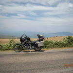 Пейзаж с мотоциклет, път и море.