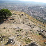 Около дървото останки от храма на Дионис. От зад на снимката турският град Бергама.